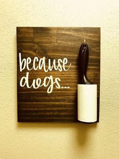 a wooden sign that says because dogs is on the wall next to a roll of toilet paper