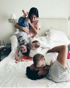 a group of people laying on top of a bed with a baby in the middle