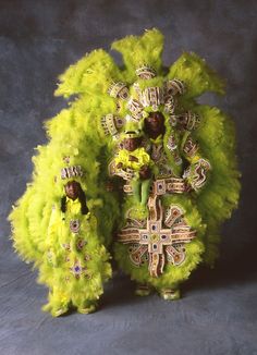 two people dressed in green and yellow costumes with flowers on their head, standing next to each other