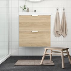 a bathroom with a stool, sink and mirror