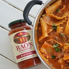 a pot filled with pasta and sauce next to a jar of margherita