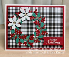 a christmas card with red and white poinsettis, holly wreath and merry christmas