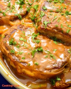 some meat covered in gravy and garnished with parsley