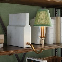 a lamp that is on top of a book shelf next to some books and pictures