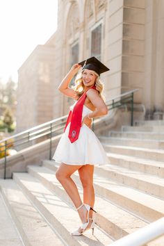 a woman in a graduation cap and gown posing on some steps with her hand on her head