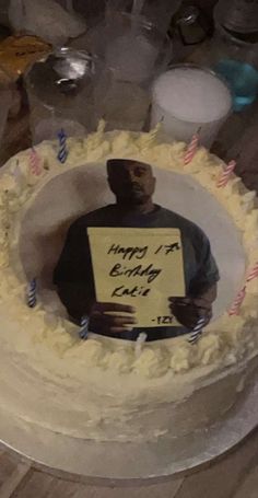 a man holding a sign in front of a cake