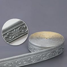 a roll of decorative silver ribbon on a gray background