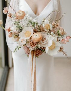 a woman holding a bouquet of flowers in her hands