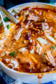 a close up of a bowl of food with meat and vegetables in it on a table