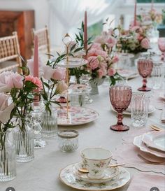 the table is set with pink roses, candles and china dishes for dinner or bridal