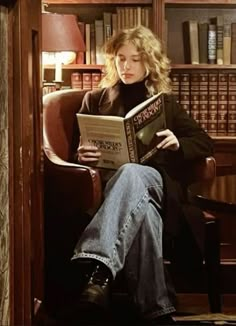 a woman sitting in a chair reading a book