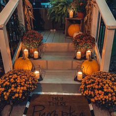 a porch with pumpkins and candles on the steps