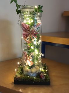 a glass jar filled with lights and flowers