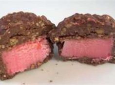 two pieces of pink cake sitting on top of a white plate