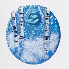 a blue plate with white birch trees in the snow and bubbles on it's surface