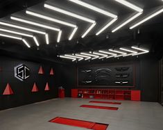 a large room with red and black flooring in the center is lit by recessed lights