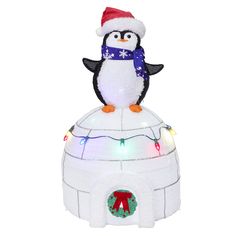 an inflatable penguin sitting on top of a building with christmas lights around it