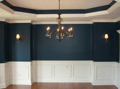 an empty room with blue walls and chandelier