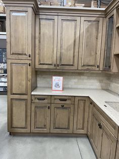 an empty kitchen with wooden cabinets and granite counter tops in a showroom area at a furniture store