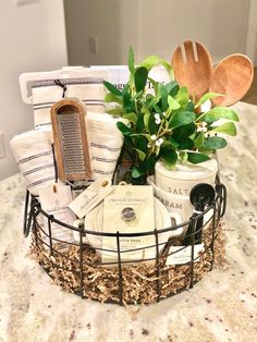 a basket filled with lots of items on top of a kitchen counter next to a potted plant