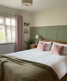 a bedroom with a large bed and green headboard