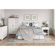 a bedroom with white furniture and wooden floors