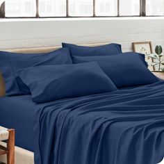 a bed with blue sheets and pillows in a room