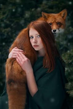 a woman with red hair is holding a fox