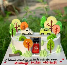 a birthday cake with cars and trees on it