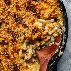 macaroni and cheese in a skillet with a wooden spoon