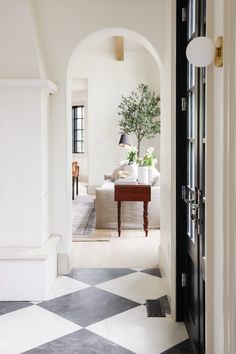 an entry way leading to a living room with a checkered black and white floor