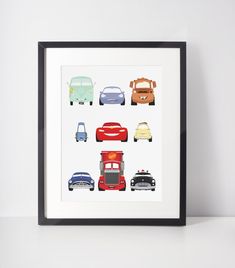 a black frame with cars and trucks in it on a white wall next to a shelf