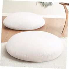 two white pillows sitting on top of a wooden floor