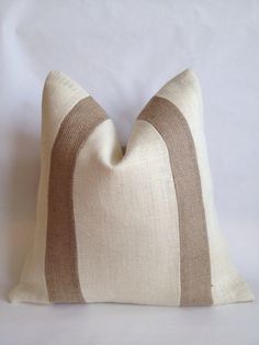 a beige and brown striped pillow on a white background