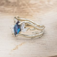 a close up of a ring on top of a wooden table with a blue stone