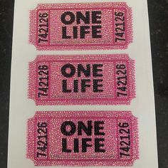 three pink tickets with one life written on them