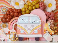 a pink and yellow vw bus clock sitting on top of a table next to balloons