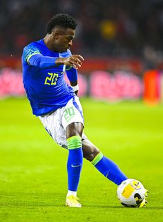 a man kicking a soccer ball on top of a field