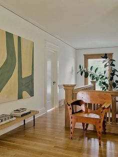 a living room filled with furniture and a painting hanging on the wall above a wooden table