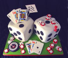 a cake made to look like two dices and playing cards on a green tray