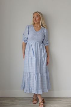 This elegant Blue Smocked Midi Dress features a flattering smocked bodice and flowing tiered midi length design. With a classy v neckline and convenient side pockets, this dress combines style and functionality for any occasion. Stay comfortable and chic in this must-have dress. v-neckline smocked bodice tiered lined side pockets true to size 100% rayon model is wearing a small Blue V-neck Tiered Dress With Ruffle Hem, Modest V-neck Dress With Smocked Back, Blue V-neck Midi Dress With Smocked Bodice, Elegant Maxi Dress With V-neck And Smocked Cuffs, Elegant Smocked Midi Dress With Ruffle Hem, Ruched Tiered Skirt Midi Dress For Daywear, Summer V-neck Midi Dress With Smocked Cuffs, Elegant Midi Smocked Dress With Ruffle Hem, Chic Tiered Dress With Smocked Cuffs