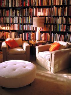 a living room filled with lots of furniture and bookshelves full of books on shelves