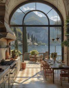 a large kitchen with an arched window overlooking the lake and mountains is pictured in this image