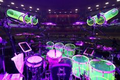 a drum set is lit up in purple and green