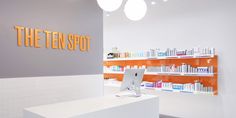 a white counter with a laptop on it in front of the ten spot store sign