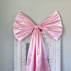 a large pink bow hanging on the side of a wall