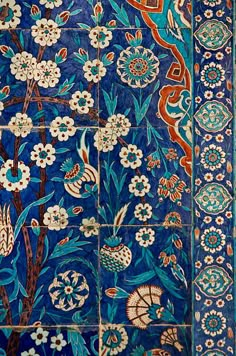 an intricately decorated wall with flowers and birds on it's side, in blue tones