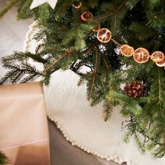 a close up of a christmas tree with ornaments on it and a ribbon tied around the tree