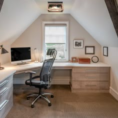 an office space with a desk, chair and computer on top of the desk is shown