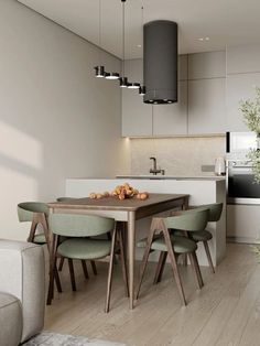 a modern kitchen and dining room with white walls, wood flooring and green chairs